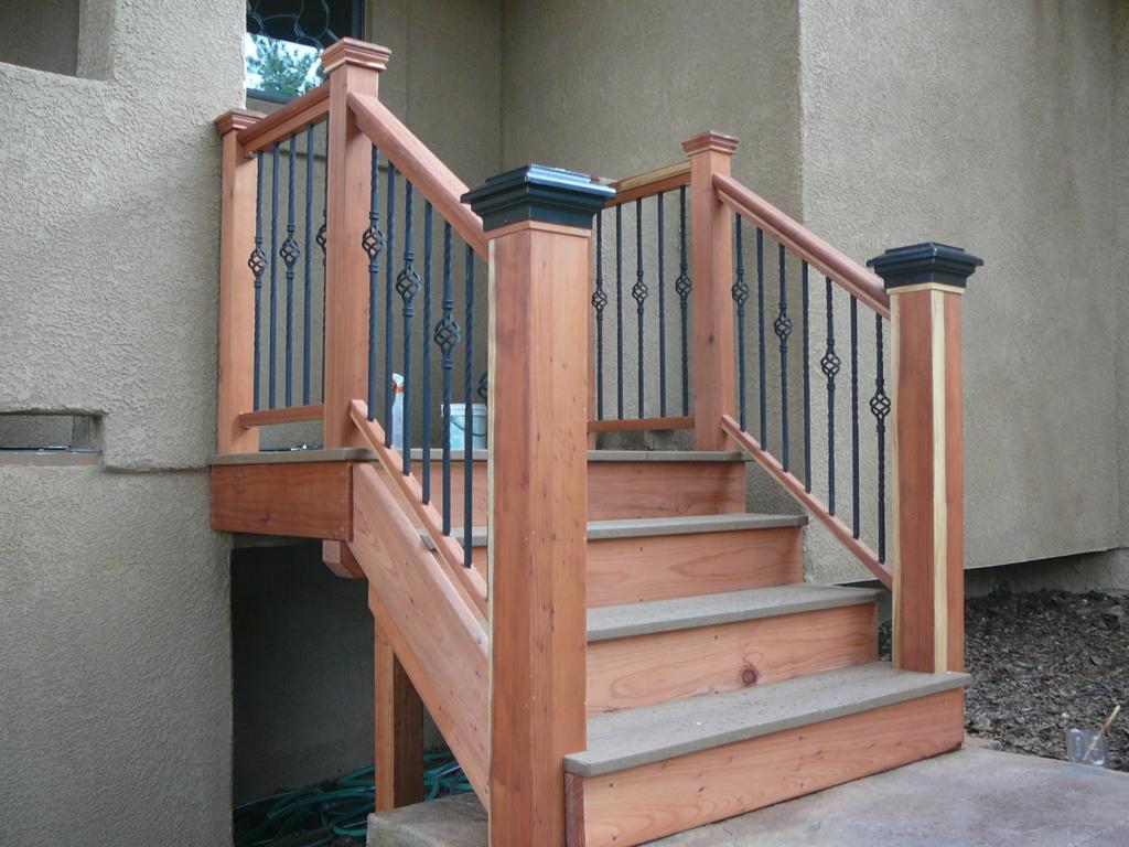 Custom built porch stairs. Walkway was raised, so I built these with a landing to compensate for the change in rise but not the run. Newel post are site fabricated and hollow, so then slid over  treated post that were concreted into the ground before walkway was poured. They're ROCK solid, yet have no finish grade lumber below ground where it can rot. Treads are composite decking for wear resistance and maintenance, the rest is hand-picked Redwood.