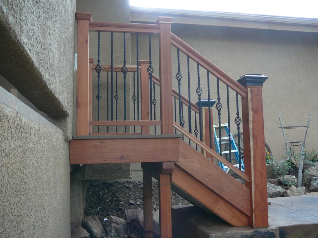 Custom built porch stairs. Walkway was raised, so I built these with a landing to compensate for the change in rise but not the run. Newel post are site fabricated and hollow, so then slid over  treated post that were concreted into the ground before walkway was poured. They're ROCK solid, yet have no finish grade lumber below ground where it can rot. Treads are composite decking for wear resistance and maintenance, the rest is hand-picked Redwood