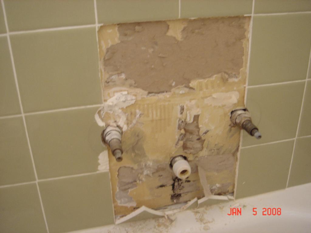 This was a valve replacement. Normally I would have just gone in from the back, but there was a marble walled shower directly opposite. So since we could not match the tile, I used a contrasting tile for the patch and tried to keep it symmetrical. Another option would have been to use a Stainless Steel repair plate, but the homeowner did not want that and in this instance it probably wouldn't have worked, since as you'll see in the next picture, I had to raise the height of the valve to allow room for the switch to a single handle valve.